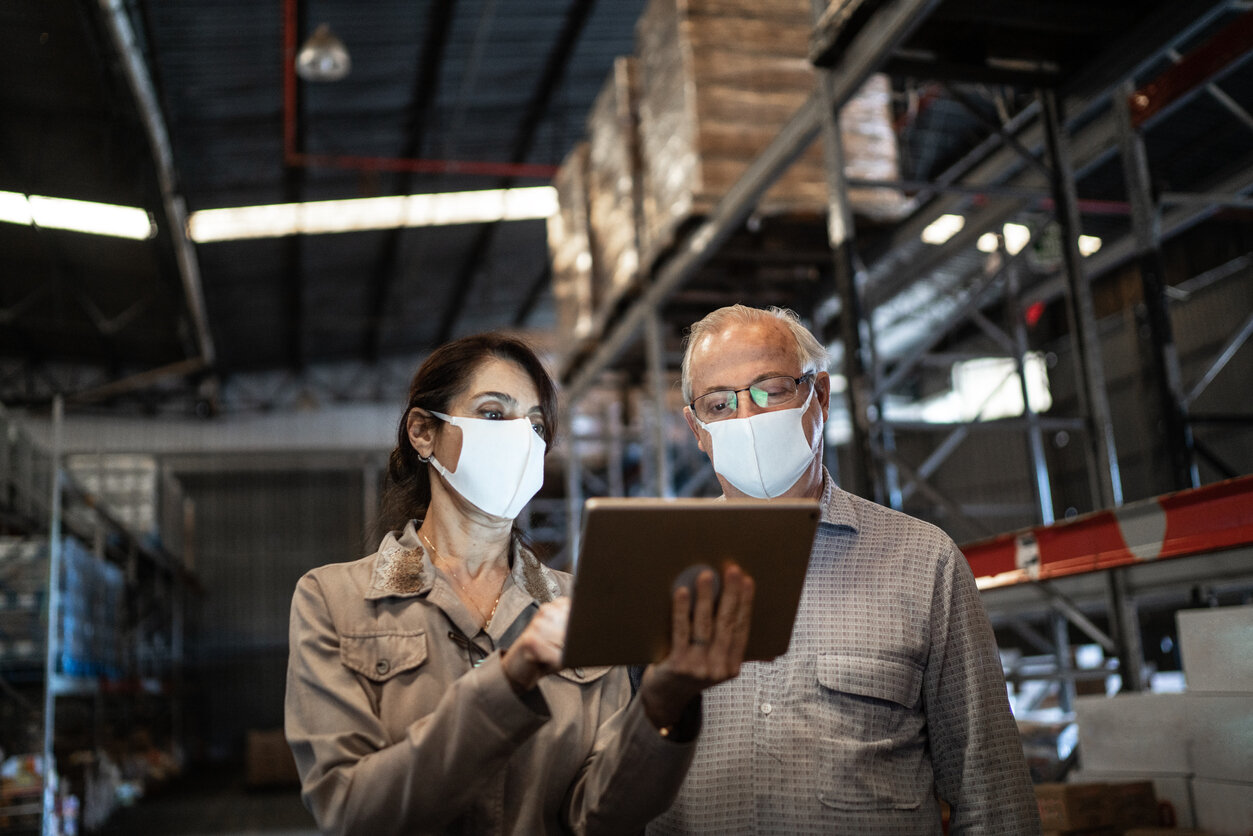 Senior partners using a tablet to look for vulnerabilities in supply chain
