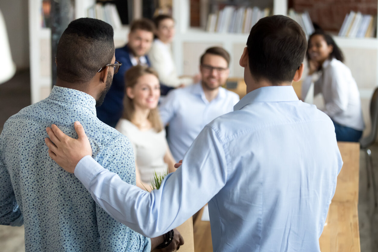 New mixed race employee having first working day in company standing in front of colleagues, executive manager employer introducing welcoming newcomer to workmates. Human resources employee retention B2B concept