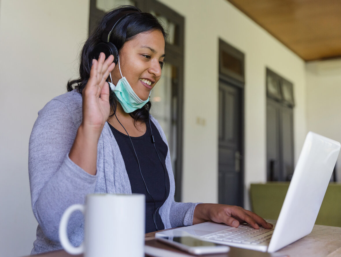 Woman working remotely video conferencing outside her home working on customer relationship management (CRM) with her team.