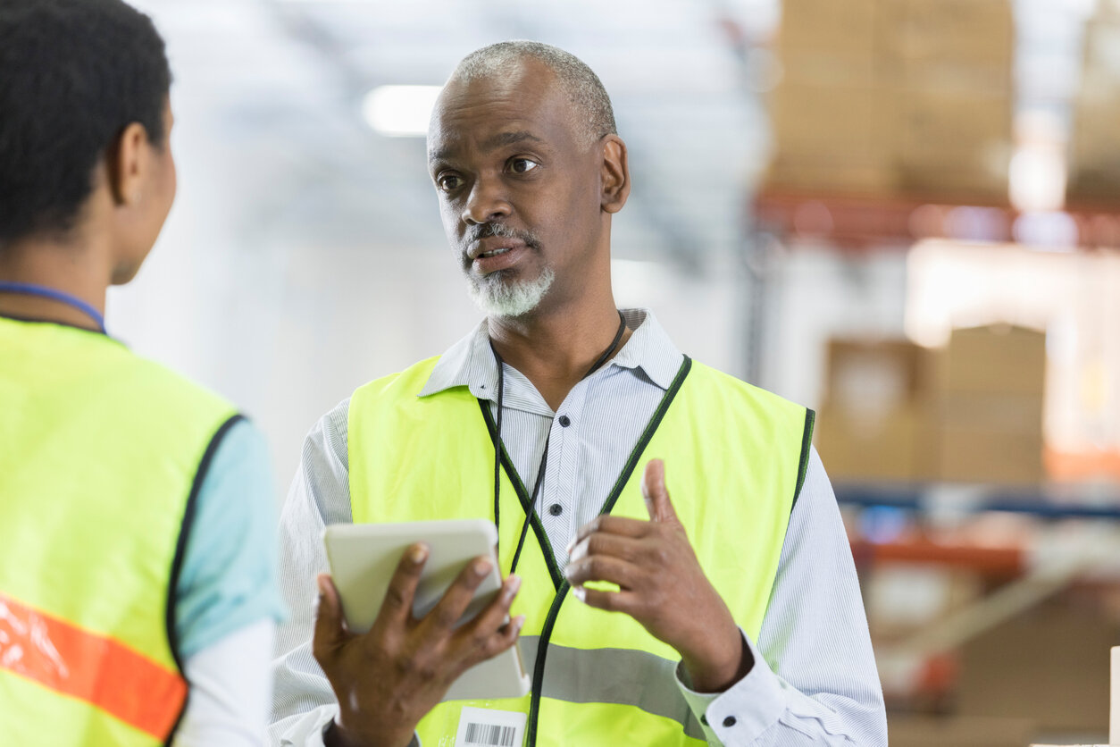 Manager and employee in a warehouse like Symbia Logistics talking with respect in the Workplace