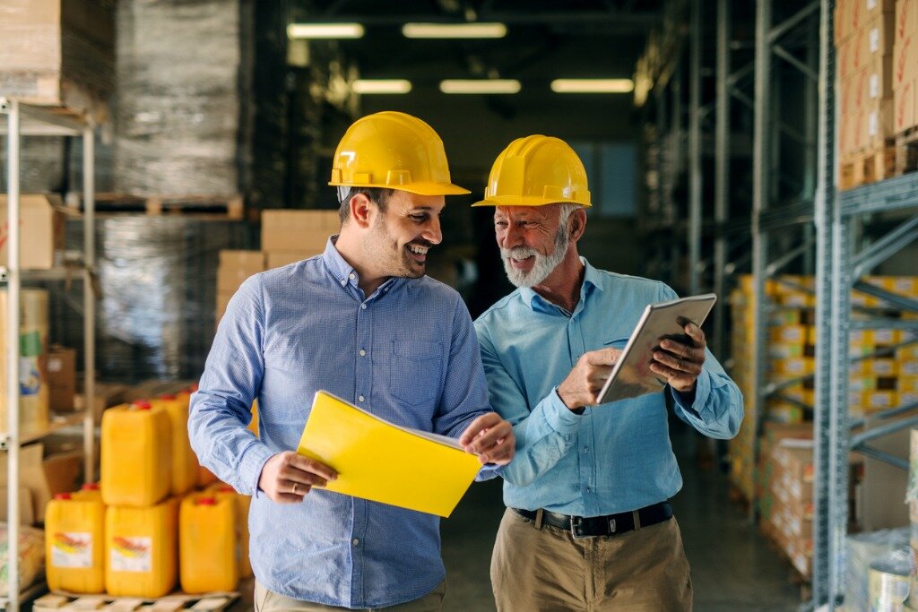 Two business managers walking and talking in a supply chain warehouse collaborating and building trust