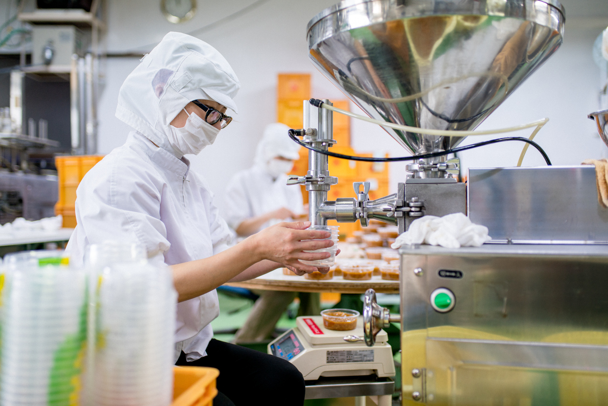 Workers in an SQF-certified food processing factory safely packaging food