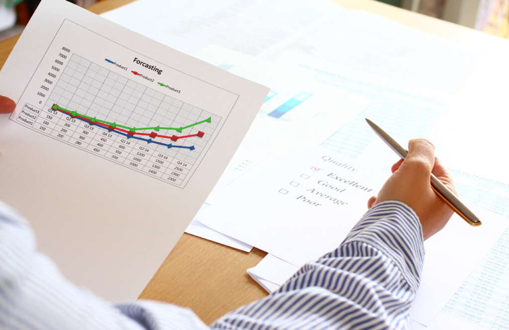 Back view of a man checking inventory forecasting growth graph results