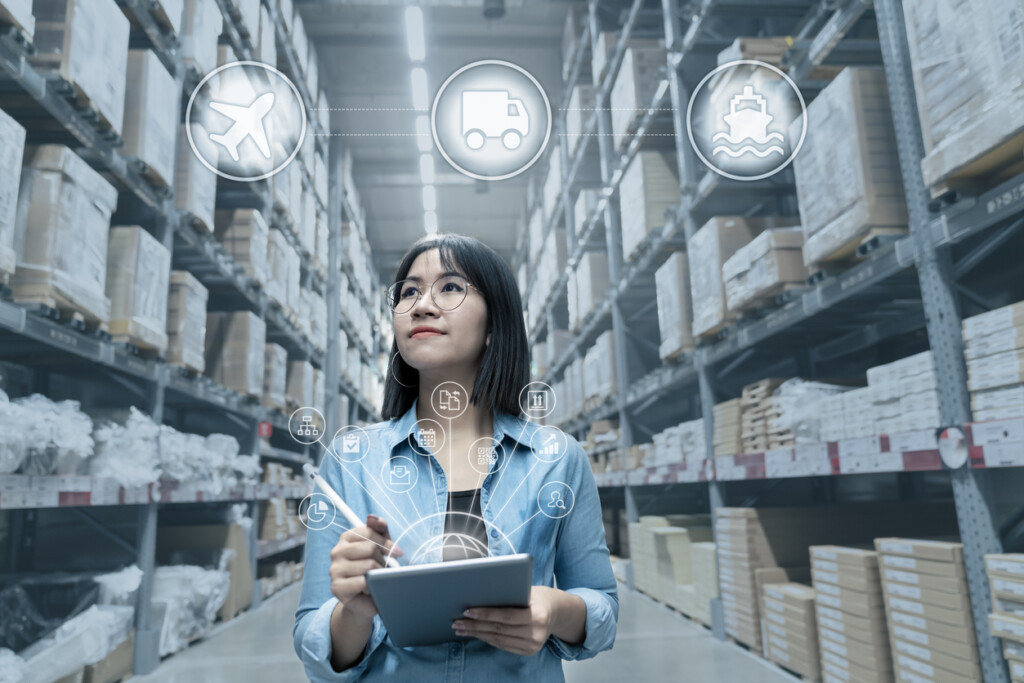 Woman looking at inventory in warehouse with smart tablet in management technology with last mile delivery-e-commerce technology solutions and delivery shipping icons