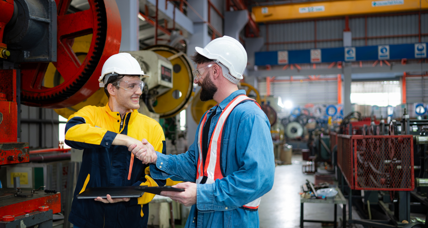 Two men in an auto parts fulfillment warehouse shaking hands on an agreement between the company and third party logistics partner