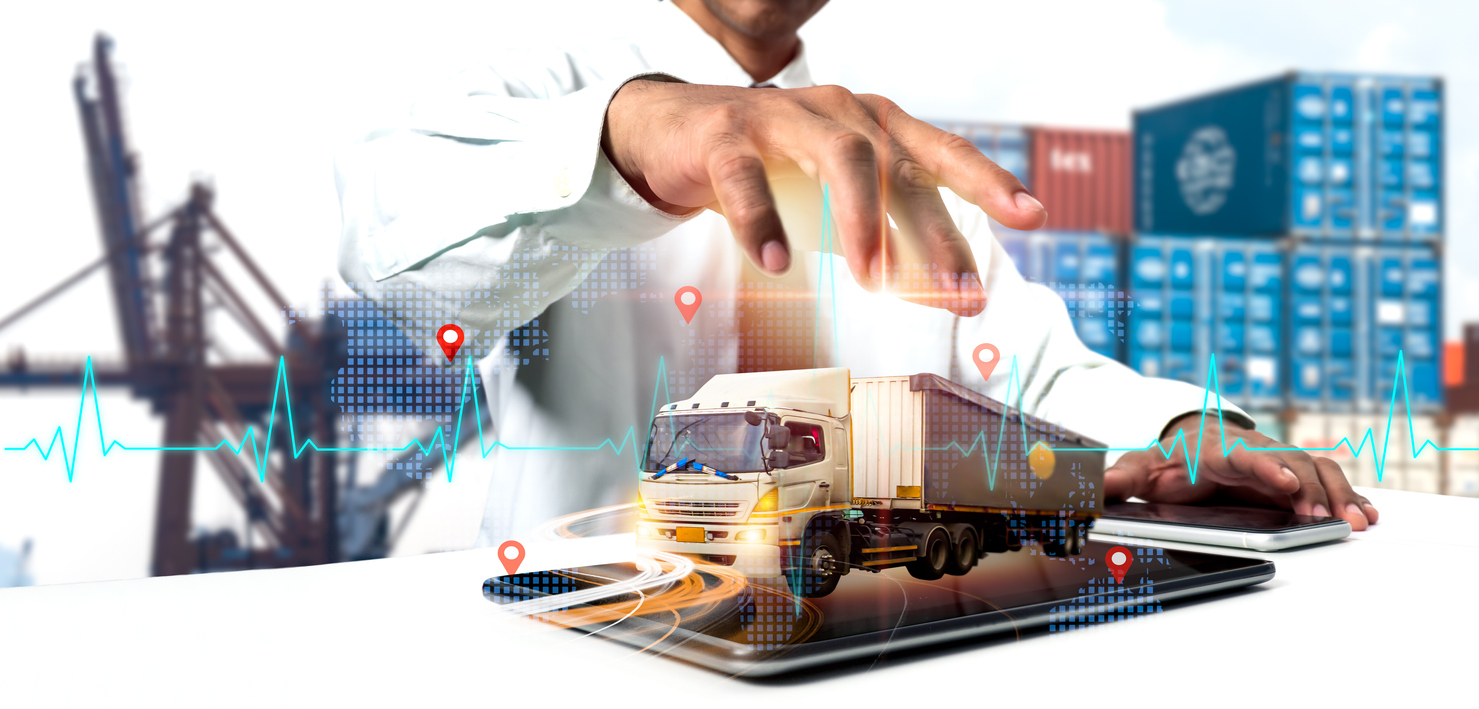 Hand over a freight truck on a tablet with a medical heartbeat overlay and location pins symbolizing the integration of technology in optimizing logistics operations and network distribution. 
