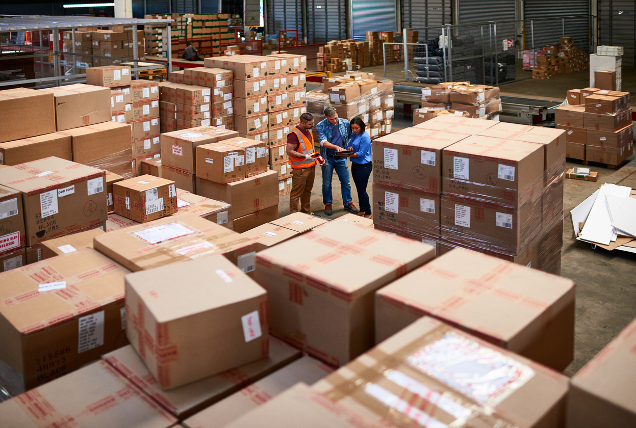 Warehouse workers using technology for control and visibility provided by a 3PL partner in inventory management.