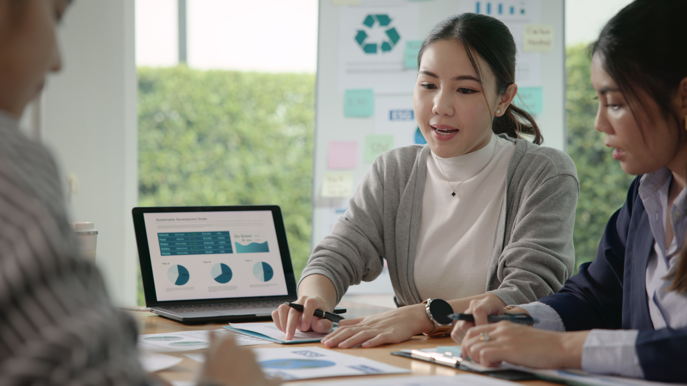 Group of people in an office meeting tracking environmental impact, with 3PL performance reporting