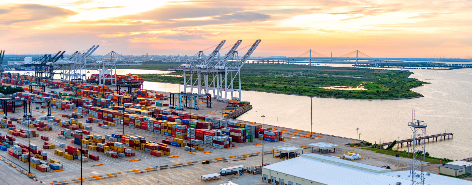 A large container ship being unloaded at the port of Houston, Texas, Morgan's Point, shot via helicopter at sunset from an altitude of about 400 feet. Shipping containers and cranes at the Port of Houston, supporting the city's emergence as a strategic fulfillment center location.