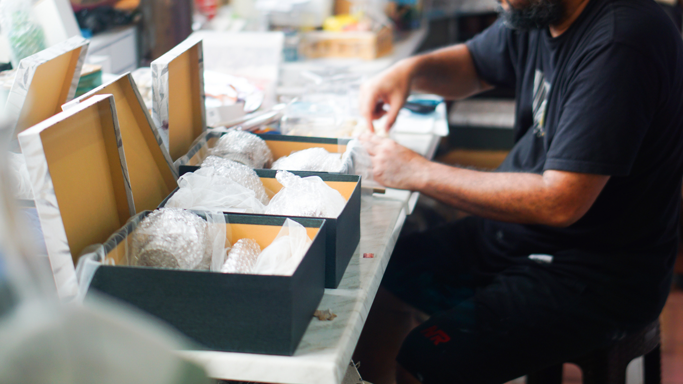 A worker is packing boxes in a warehouse, doing manual education fulfillment services