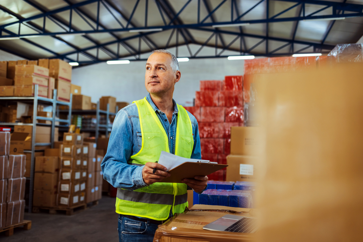 Warehouse team member reviewing a checklist in a distribution center, highlighting performance evaluation in publisher fulfillment strategy.