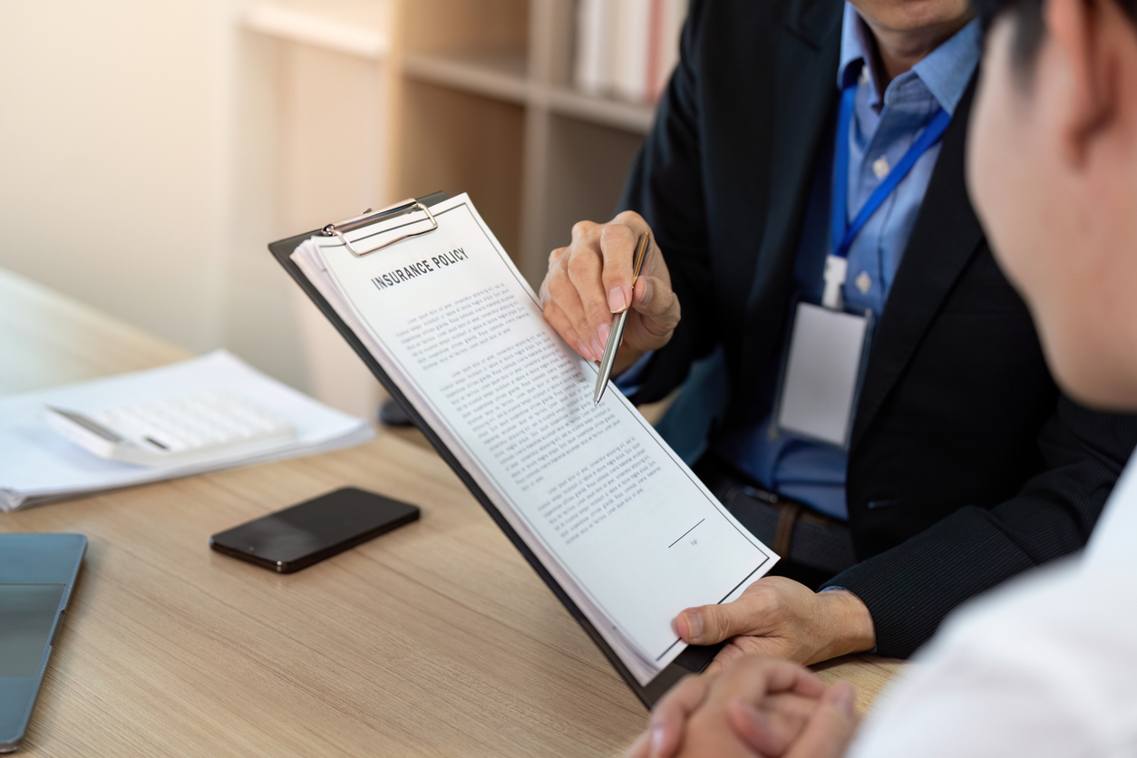A professional insurance agent explains policy details, reviewing the insurance policy in detail, emphasizing verification of warehouse legal liability insurance terms.