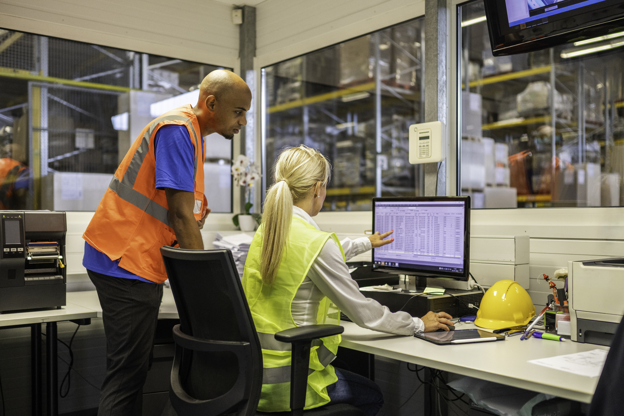 Shipping operator showing order list to warehouse worker, highlighting collaboration when implementing eCommerce SKUs strategy.