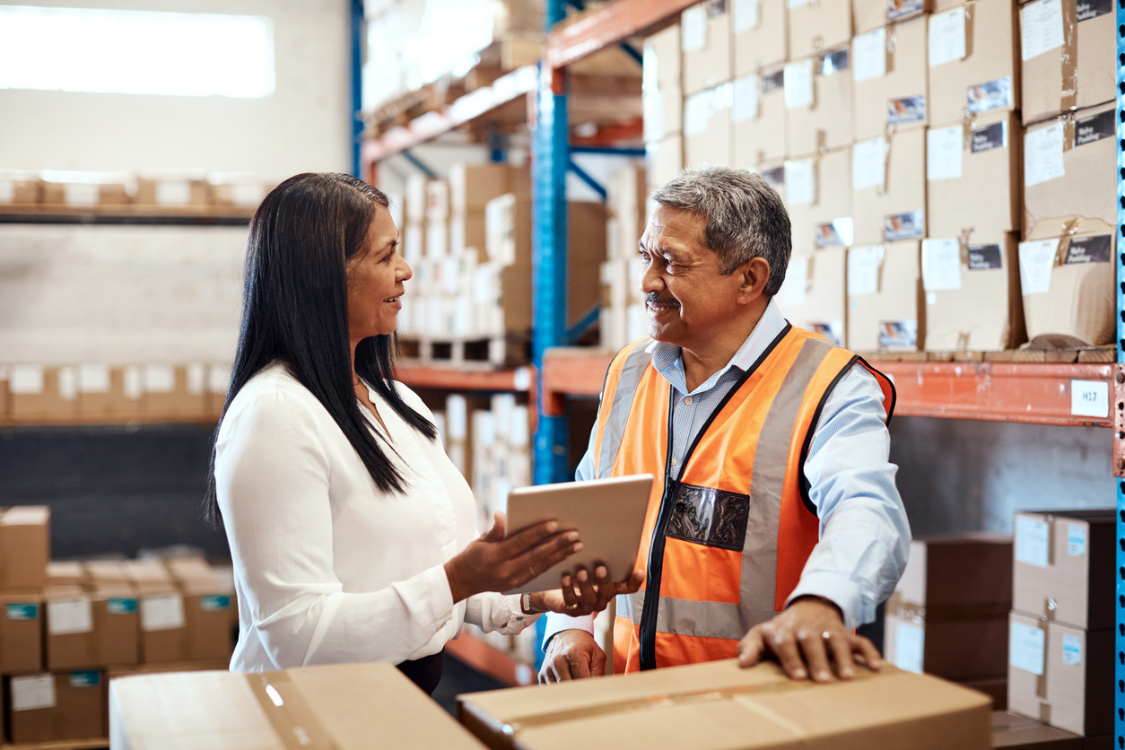 CPG fulfillment planning between warehouse manager and operations staff inside a regional warehousing facility.